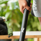 A close-up of a person's hand holding a black steel mace.